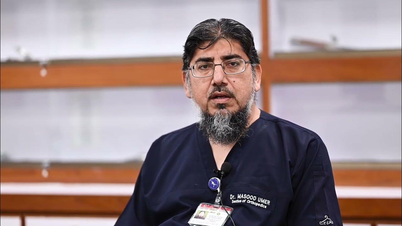Dr. Masood Umer in professional medical scrubs at hospital
